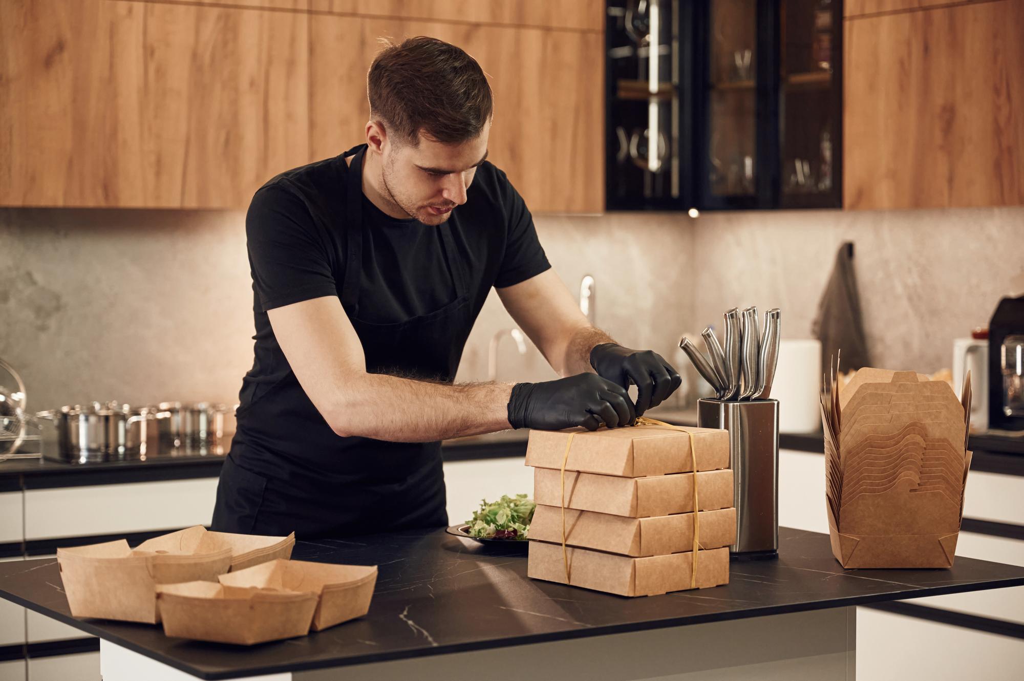 Chef packing meal boxes in a clean facility